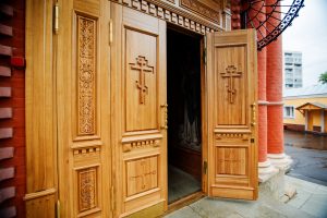 Open door to an Orthodox church with crosses on the doors.